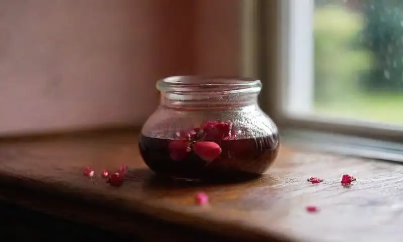 Pétalos de rosa vibrantes y aterciopelados adornan una mesa de madera