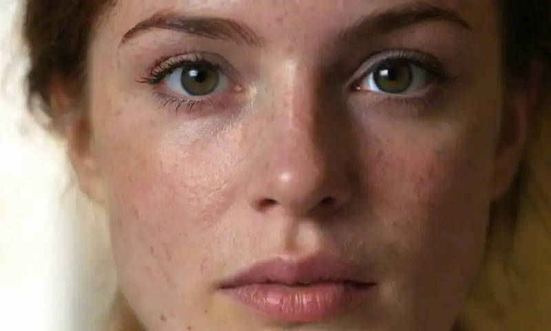 Primer plano de una mujer con rostro emotivo y vulnerable, iluminado suavemente, que refleja tristeza y fragilidad